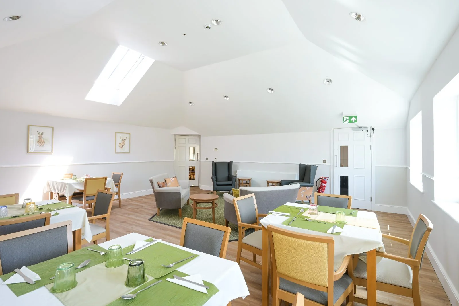 Dining room with framed animal prints and a skylight