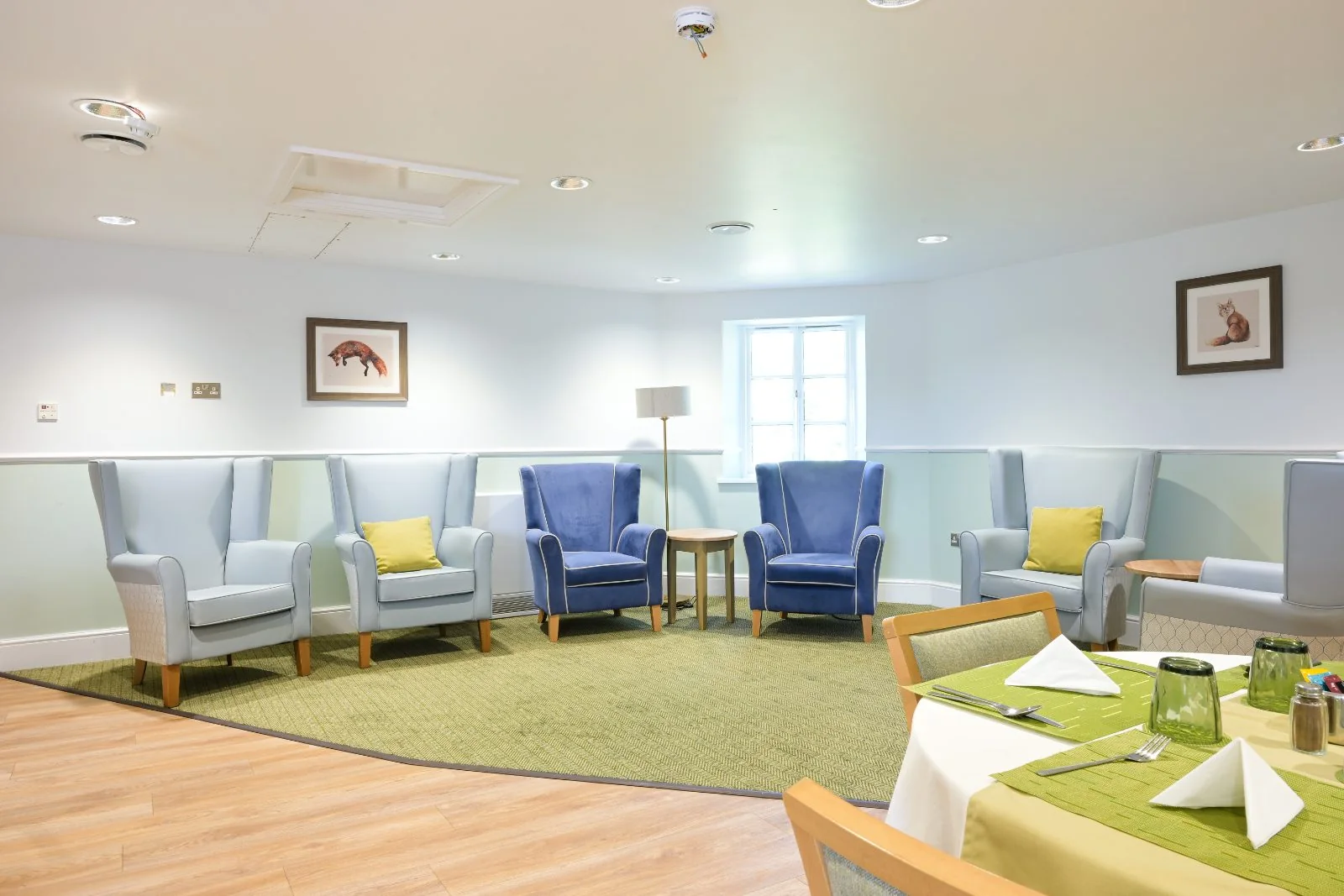 Lounge with blue and pale-grey armchairs and a floor lamp
