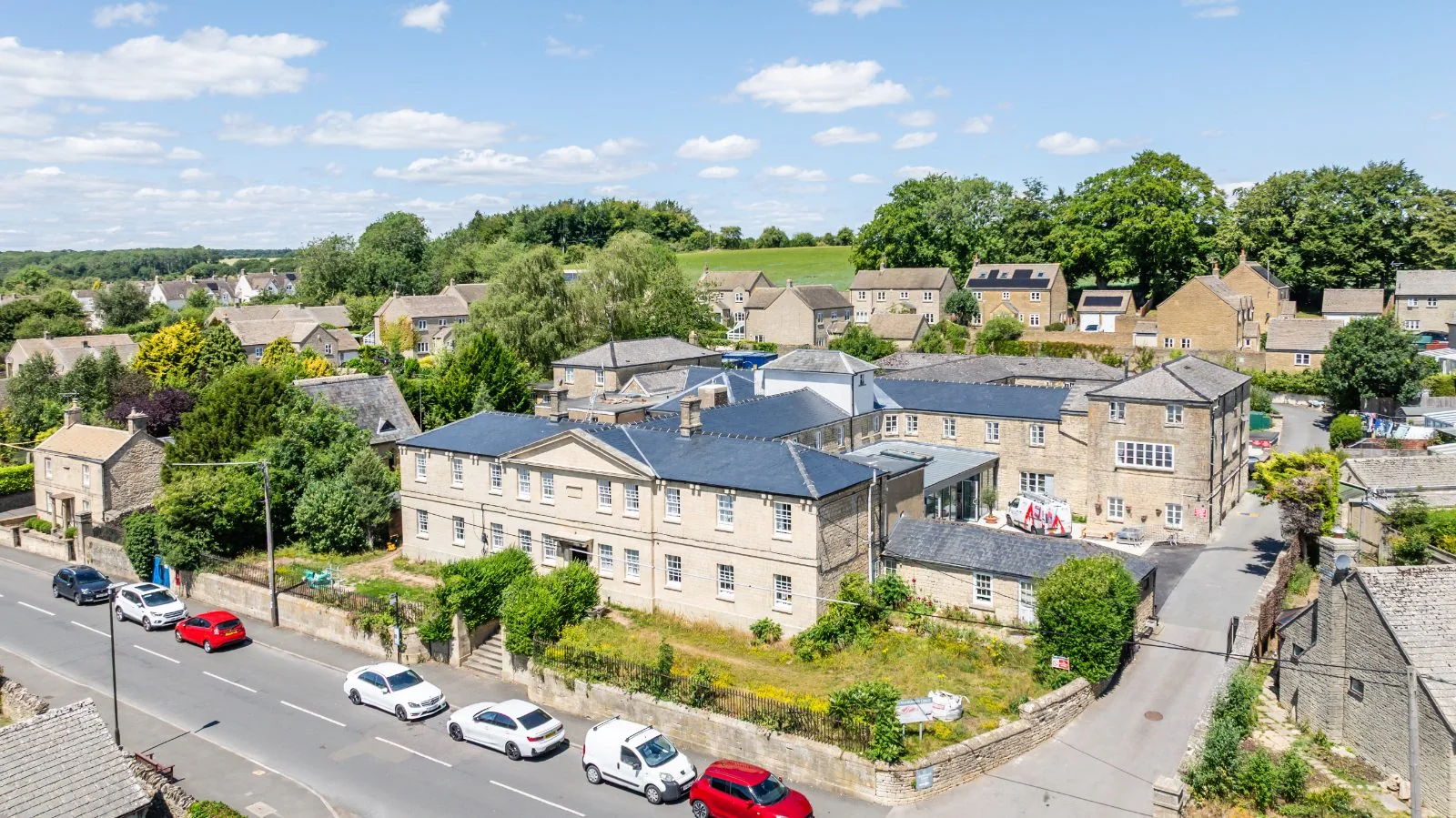 Aerial view of Northleach Court among Cotswold-stone houses and fields