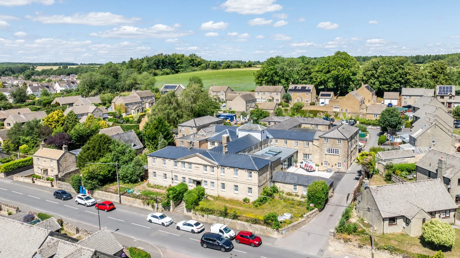 Aerial view of the home with fields and trees behind